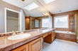 Large luxury bathroom with red granite countertops and tub.