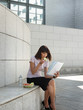 Photo: business person eating lunch outside office and reading papers business person eating lunch outside office and reading papers