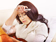 Woman with thermometer having  flue in bed.