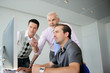 Three business colleagues gathered around computer