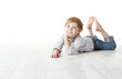 Photo: Child lying down on floor and looking at camera Child lying down on floor and looking at camera