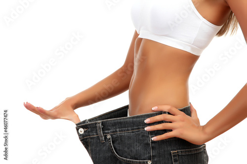 Photo: beautiful young woman with big jeans, isolated on white beautiful young woman with big jeans, isolated on white