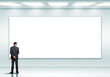 Business person standing near a blank billboard