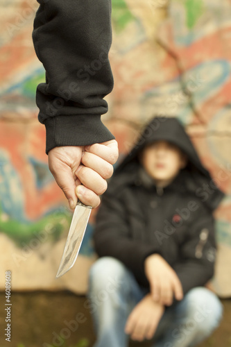 Photo: Boy looks at a man with a knife Boy looks at a man with a knife