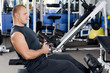 Foto: Man on training apparatus in club Man on training apparatus in club