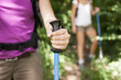 Photo: young women trekking in forest and holding stick young women trekking in forest and holding stick
