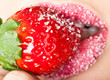 woman's mouth with red strawberry covered with sugar