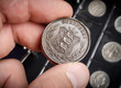 The numismatist examines a coin from the collection