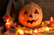 halloween pumpkin and autumn leaves, on wooden background
