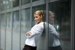 confident woman leaning on office building window