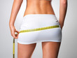 Photo: Sporty woman with slim body measuring hips Sporty woman with slim body measuring hips