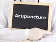Doctor shows information on blackboard: acupuncture