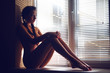 beautiful naked young woman on the window