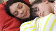 Mother And Daughter Relaxing On Sofa Together