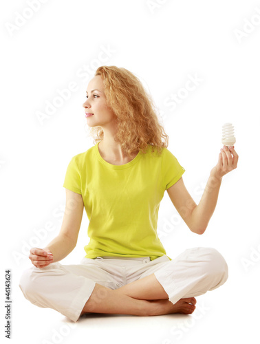 Photo: A woman with an energy-saving bulb meditating, isolated on white A woman with an energy-saving bulb meditating, isolated on white