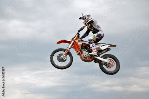 Photo: motocross rider jumps high against the sky motocross rider jumps high against the sky