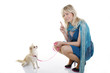 Blonde Frau gibt Chihuahua Sitz Zeichen