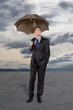 Businessman with umbrella under a stormy sky