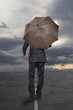 Businessman with umbrella under a stormy sky
