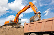 Photo: Backhoe loading soil or sand into dump truck body Backhoe loading soil or sand into dump truck body