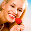 Foto: Young woman with strawberry on beach Young woman with strawberry on beach
