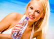 Woman with bottle of water on beach
