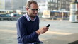 Man with smartphone sitting in the city, steadicam shot