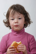 Foto: A young girl eating a bun A young girl eating a bun