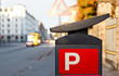 red parking sign with city background