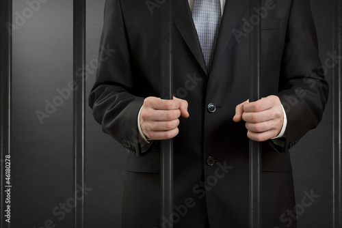Photo: Businessman in jail close up Businessman in jail close up