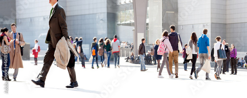 Photo: People walking against a light background. People walking against a light background.