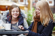 two young women sitting in a sidewalk café