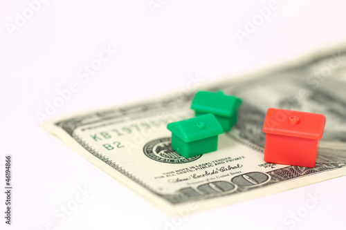 Photo: Monopoly houses and hotel on 100 dollar banknote Monopoly houses and hotel on 100 dollar banknote