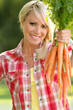 Blonde Farm Girl Displaying Carrots