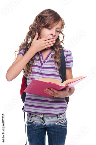 Photo: little girl reading book and yawning little girl reading book and yawning