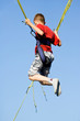 Little boy jumping on the trampoline (bungee jumping).