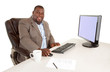 Photo: Smiling African American Businessman Sitting at Desk Smiling African American Businessman Sitting at Desk