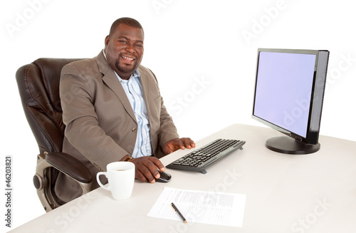 Photo: Smiling African American Businessman Sitting at Desk Smiling African American Businessman Sitting at Desk