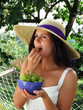 Joven mujer comiendo uvas.Mujer fruta en un jardín.