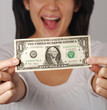Joven mujer sujetando un billete de un dólar.