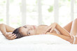 Portrait of young beautiful woman  in bed on color back