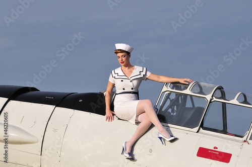 Photo: retro navy girl with a vintage aircraft retro navy girl with a vintage aircraft