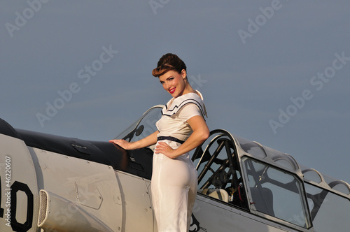 Photo: retro navy girl with a vintage aircraft retro navy girl with a vintage aircraft