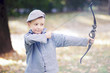 Junge spielt mit Pfeil und Bogen im Park