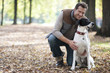 Mann geht mit Hund im Wald spazieren