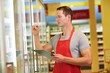 Mitarbeiter kontrolliert Warenbestand im Supermarkt