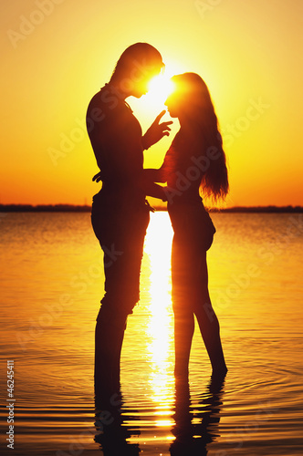 Photo: Couple silhouette at the beach. Sunset light. Couple silhouette at the beach. Sunset light.