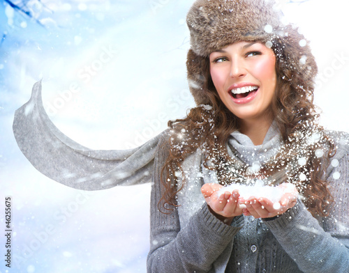 Photo: Christmas Girl. Winter woman Blowing Snow Christmas Girl. Winter woman Blowing Snow