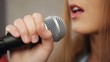 Close-up of singer touching microphone  singing