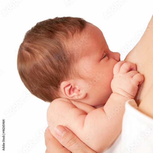 Photo: Newborn tiny baby breast feeding closeup. Isolated on white Newborn tiny baby breast feeding closeup. Isolated on white